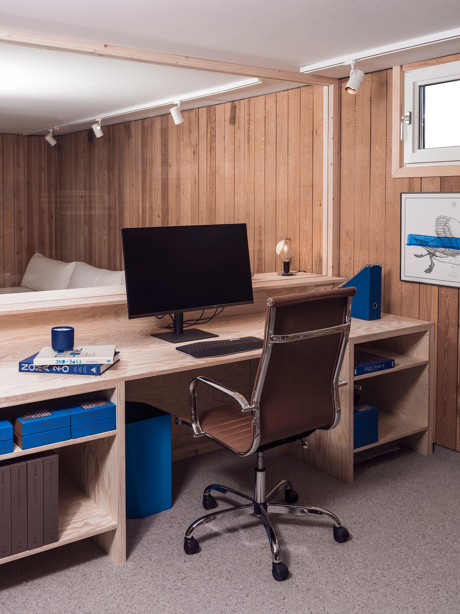 Arbetplats med skrivbord, skärm och stol.